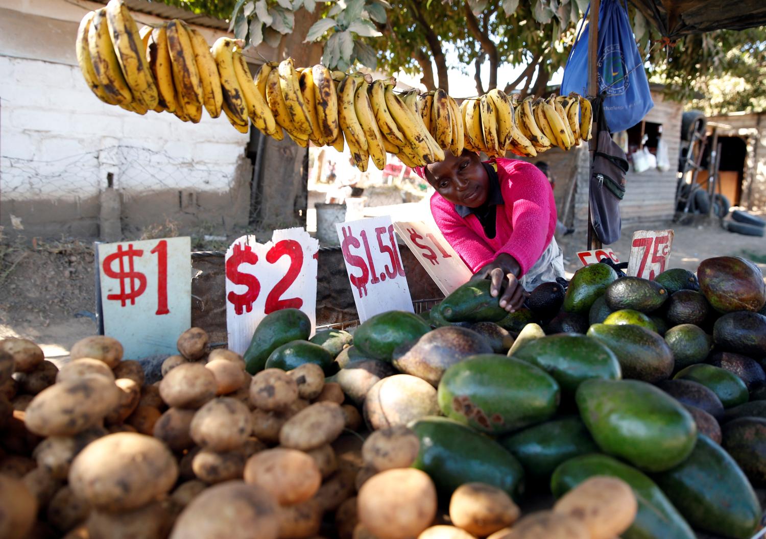 A street vendor sells vegetables at a market place in Chitungwiza, Zimbabwe, July 16, 2019. Picture taken July 16, 2019. REUTERS/Philimon Bulawayo - RC1929F5F700