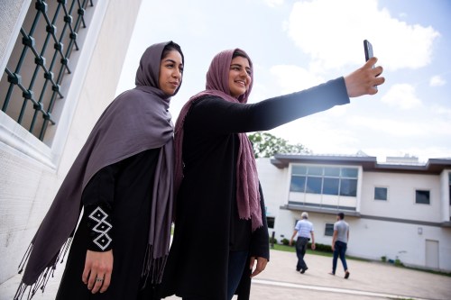 Two Muslim women take pictures after the first Friday prayers during the month of Ramadan at Diyanet Center of America in Lanham, Maryland, U.S., May 10, 2019. REUTERS/Amr Alfiky - RC15CA4BC8D0