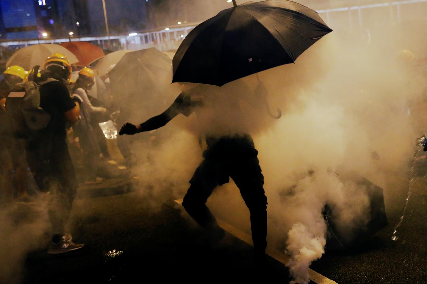 Pro-democracy protesters use umbrellas to protect themselves from tear gas during a protest against police violence during previous marches, near China's Liaison Office, Hong Kong, China July 28, 2019. REUTERS/Tyrone Siu - RC1304E1DFD0