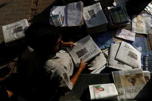 A hawker sorts out newspapers as he sells them along a street in Karachi, Pakistan October 7, 2018. Picture taken October 7, 2018. REUTERS/Akhtar Soomro - RC1F71201BE0