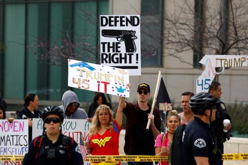 Counter-protesters carrying signs in support of guns and Trump stand across from "March for Our Lives", an organized demonstration to end gun violence, in downtown Los Angeles, California, U.S., March 24, 2018.  REUTERS/Patrick T. Fallon - RC1DC45DF570