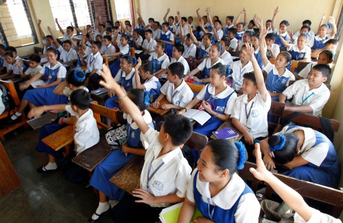 Students raise their hands to answer questions in a classroom at a public high school in Paranaque city, metro Manila February 17, 2011. REUTERS/Romeo Ranoco (PHILIPPINES - Tags: EDUCATION) - GM1E7480UJO01