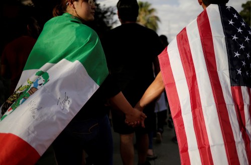 People with the Mexican flag and the U.S. flag take part in a rally against hate a day after a mass shooting at a Walmart store, in El Paso, Texas, U.S. August 4, 2019. REUTERS/Jose Luis Gonzalez     TPX IMAGES OF THE DAY - RC119E6AB8E0