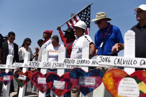 People pray next to a row of crosses representing each of the victims at a growing memorial site two days after a mass shooting at a Walmart store in El Paso, Texas, U.S. August 5, 2019.  REUTERS/Callaghan O'Hare - RC15060501D0