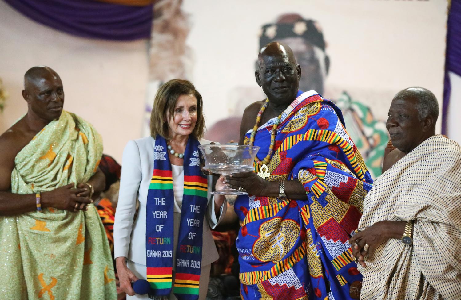 U.S. Speaker of the House Nancy Pelosi poses for a photograph after presenting a gift to Paramount Chief of Cape Coast traditional area, Osabarima Kwesi Atta II, during her visit to a palace used by the Chief after her tour at the Cape Coast Castle which was used as a trading post from where slaves would be taken to America, in Ghana July 30, 2019. REUTERS/Siphiwe Sibeko - RC14F026AA40