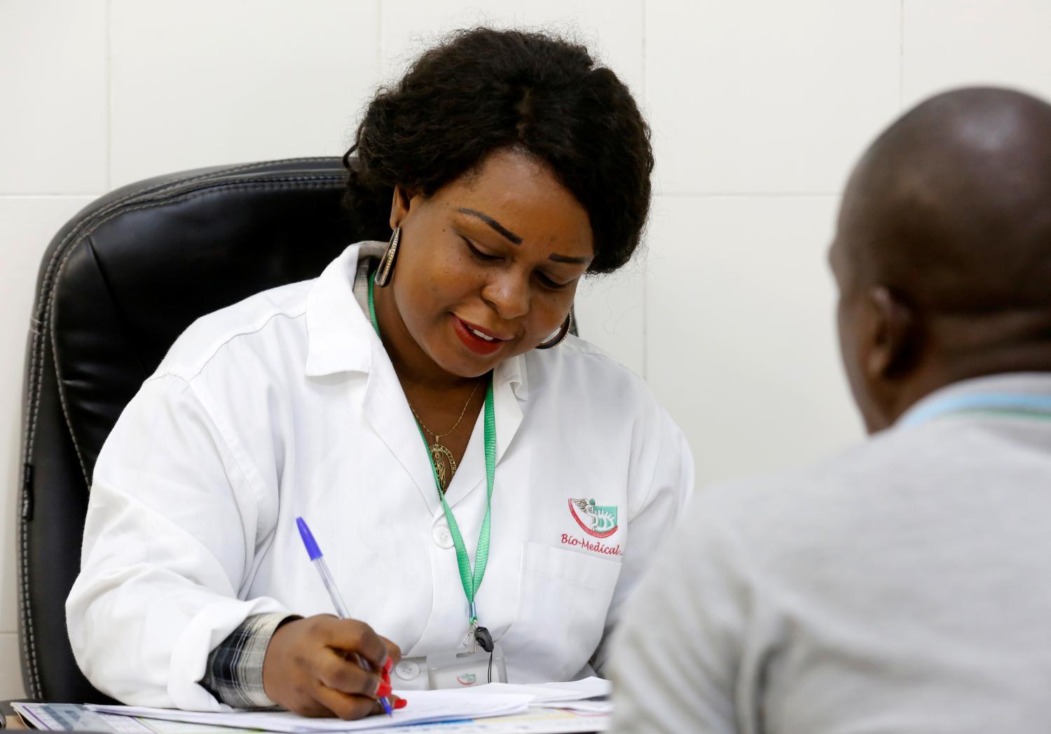 Dr. Christelle Azier-Pohoun of BIO-MEDICAL, a center that provides medical visits for people who pass the driver's license, speaks to a patient during a consultation in Abidjan, March 28, 2019. REUTERS/Thierry Gouegnon. - RC1BC64E9F30
