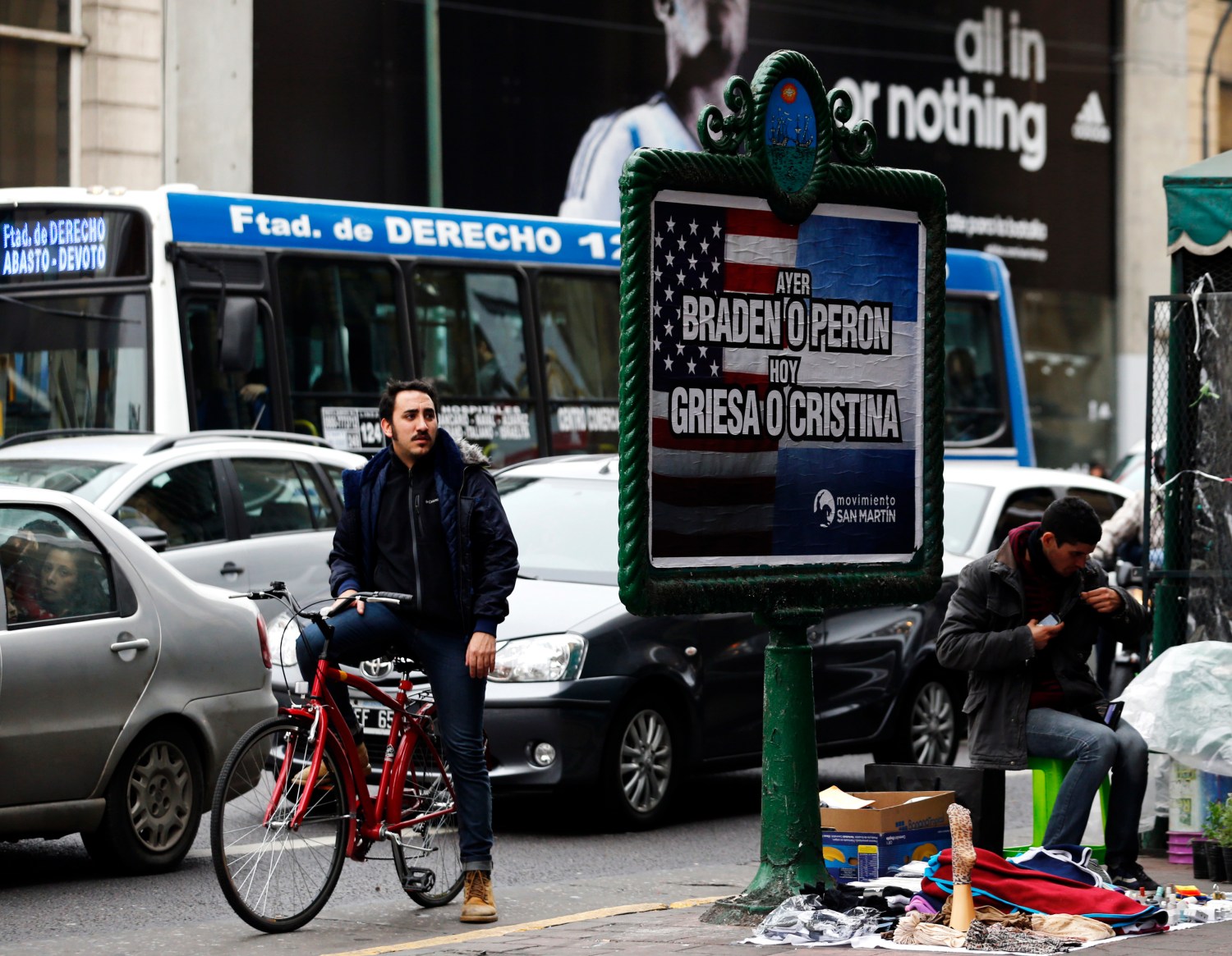 A man looks at a poster placed on an advertising board that reads "Yesterday, Braden or Peron - Today: Griesa or Cristina", in Buenos Aires July 29, 2014. Argentine debt negotiators held talks in New York on Tuesday with the U.S. mediator in the South American country's battle with holdout investors, in a last-ditch attempt to avert a default. After a series of setbacks in U.S. courts, Argentina has until the end of Wednesday to either pay the New York hedge funds in full their defaulted bonds resulting from the country's 2001/02 financial crisis or cut a deal to stave off a fresh default. The poster refers to 1945 U.S. Ambassador in Argentina Braden Spruille, former Argentina's President Juan Peron, U.S. District Court for the Southern District of New York Judge Thomas Griesa and President of Argentina  Cristina Fernandez de Kirchner.   REUTERS/Marcos Brindicci (ARGENTINA - Tags: POLITICS BUSINESS SOCIETY) - GM1EA7U09E501