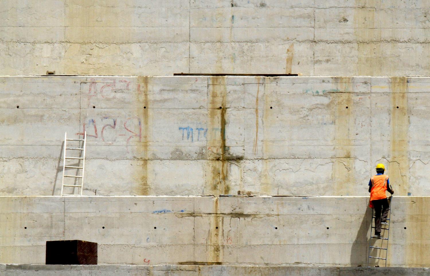 A construction worker is seen at a distance in a section of Ethiopia's Grand Renaissance Dam, as it undergoes construction, during a media tour along the river Nile in Benishangul Gumuz Region, Guba Woreda, in Ethiopia March 31, 2015. According to a government official, the dam has hit the 41 percent completion mark. Picture taken March 31, 2015. REUTER/Tiksa Negeri  - GF10000046011