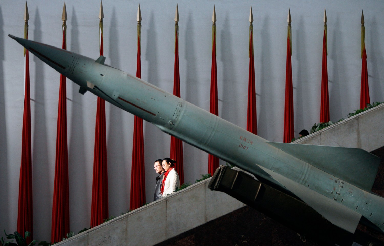 Visitors walk past a Chinese-made Hongqi-2 missile at the Military Museum in Beijing February 23, 2007. .S. Vice President Dick Cheney on Friday expressed concerns about China's military build-up and also questioned whether North Korea would follow through on its commitments in a recent nuclear deal.   REUTERS/Claro Cortes IV   (CHINA) - GM1DUREPYYAA