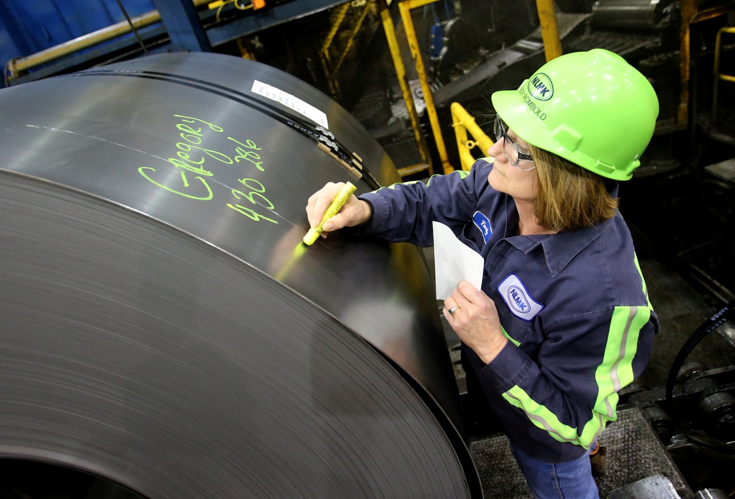 A finished steel coil is marked with its information by a worker at the Novolipetsk Steel PAO steel mill in Farrell, Pennsylvania, U.S., March 9, 2018. REUTERS/Aaron Josefczyk - RC1293A04C30