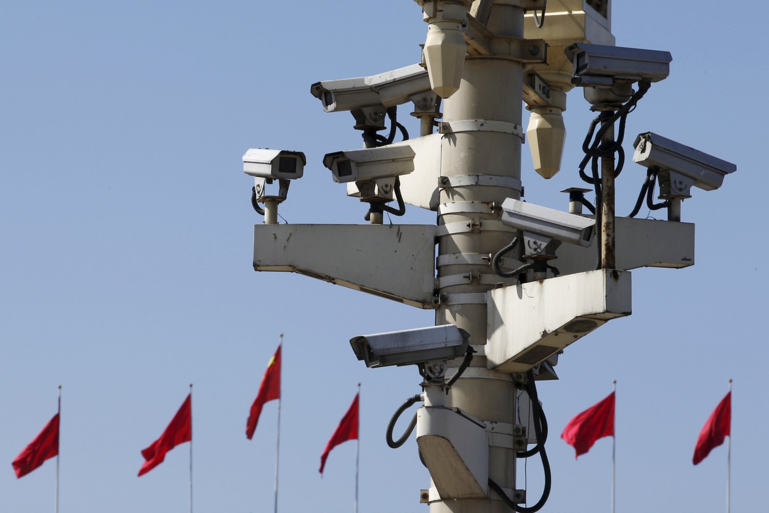 Security cameras in Tiananmen square are seen in front of flags on the Great Hall of the People where the National People's Congress (NPC) is being held, in Beijing, China, March 11, 2016. REUTERS/Kim Kyung-Hoon - GF10000341408