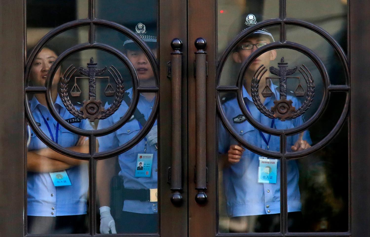 Police officers stand next to the door of the Jinan Intermediate People's Court building, where the trial of disgraced Chinese politician Bo Xilai will be held in Jinan, Shandong province August 21, 2013. One of the charges against Bo relates to his flouting the authority of central leaders in Beijing, sources said, an allegation so sensitive that his trial could start one day sooner to hear it in secret. The charge is abuse of power, and the accusation is that Bo challenged and ignored the will and rules of the ruling Communist Party, the sources said. Bo is also accused of corruption and taking bribes, but that charge is likely to be heard on Thursday, when the trial is officially scheduled to begin, in a supposedly open session in the court in the eastern city of Jinan. REUTERS/Carlos Barria (CHINA - Tags: POLITICS) - GM1E98L0Q3002