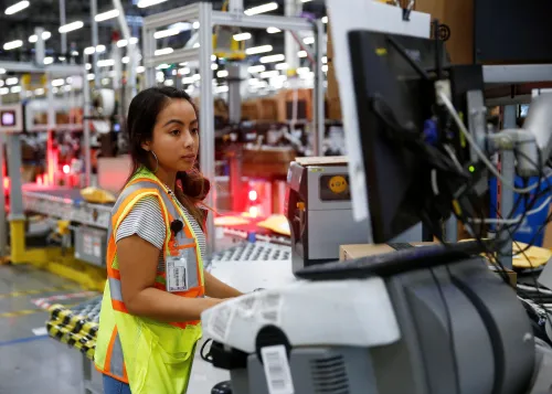 Employee Stanaleen Greenman works on processing packages kicked out by the automated scanning and labeling system at the Amazon fulfillment center in Kent, Washington, U.S., October 24, 2018.  REUTERS/Lindsey Wasson - RC1C49A3AD10