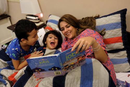 Amirah al-Turkistani, a graphic design lecturer at Jeddah University, reads a bedtime story to her children at her house in Jeddah, Saudi Arabia, October 23, 2017. REUTERS/Reem Baeshen  SEARCH "BAESHEN WOMEN" FOR THIS STORY. SEARCH "WIDER IMAGE" FOR ALL STORIES. - RC12949DD6F0