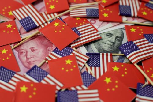 FILE PHOTO: A U.S. dollar banknote featuring American founding father Benjamin Franklin and a China's yuan banknote featuring late Chinese chairman Mao Zedong are seen among U.S. and Chinese flags in this illustration picture taken May 20, 2019. REUTERS/Jason Lee/File Photo - RC1965288CA0