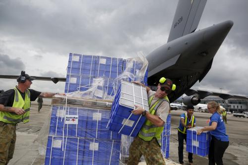 Air crew and volunteers unload aid from a Royal Australian Air Force (RAAF) transport plane carrying donated aid for Myanmar's flood victims at Yangon international airport in Yangon on August 10, 2015. REUTERS/Soe Zeya Tun - GF20000018961