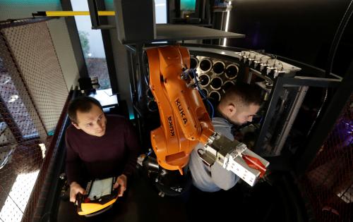 Technicians maintain a robotic bartender inside a space modul-like structure before its official opening in Prague, Czech Republic, November 28, 2018. REUTERS/David W Cerny - RC149B21AD60