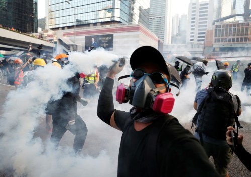 An anti-government protester throws back a tear gas canister at the police during a demonstration near Central Government Complex in Hong Kong, China, September 15, 2019. REUTERS/Jorge Silva - RC14CEE90590