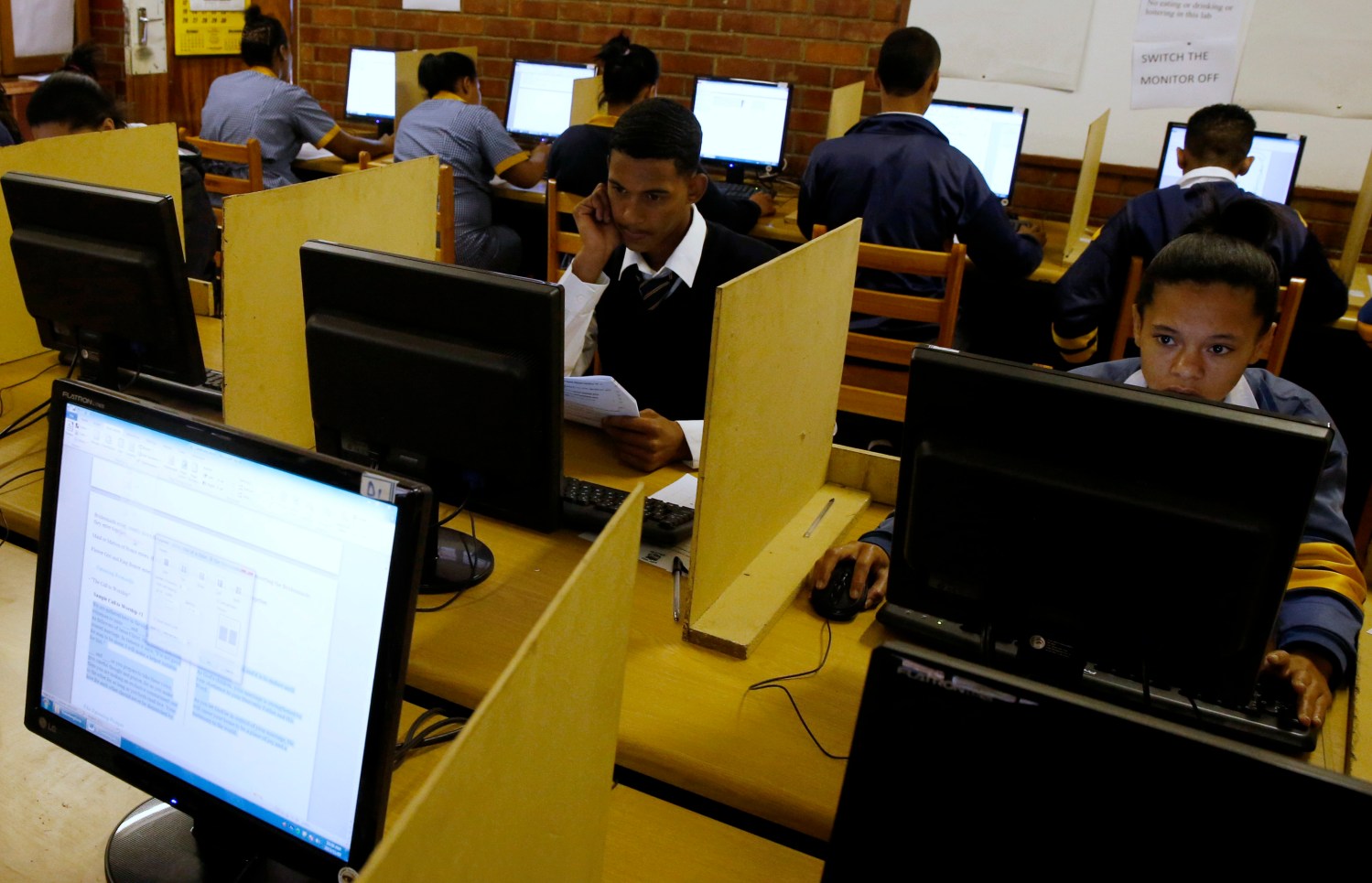 Students use computers to study at Elswood Secondary School in Cape Town November  7, 2013. Even the metal grills welded into its walls did not deter burglars from ripping out the copper cables that delivered Internet to the students of this tough neighbourhood. But Elswood's pupils were saved by alternative technology - free wireless connection via unused TV spectrum known as white space. It's being provided by a consortium including Google  as part of a wider trial. Elsewhere in the country Microsoft  is operating similar pilots. Both are racing to fine tune a technology that could ultimately bring cheap broadband to the entire continent. Picture taken November 7, 2013. To match Feature AFRICA-INTERNET/ REUTERS/Mike Hutchings  (SOUTH AFRICA - Tags: EDUCATION BUSINESS SCIENCE TECHNOLOGY) - GM1E9BA1EGA01