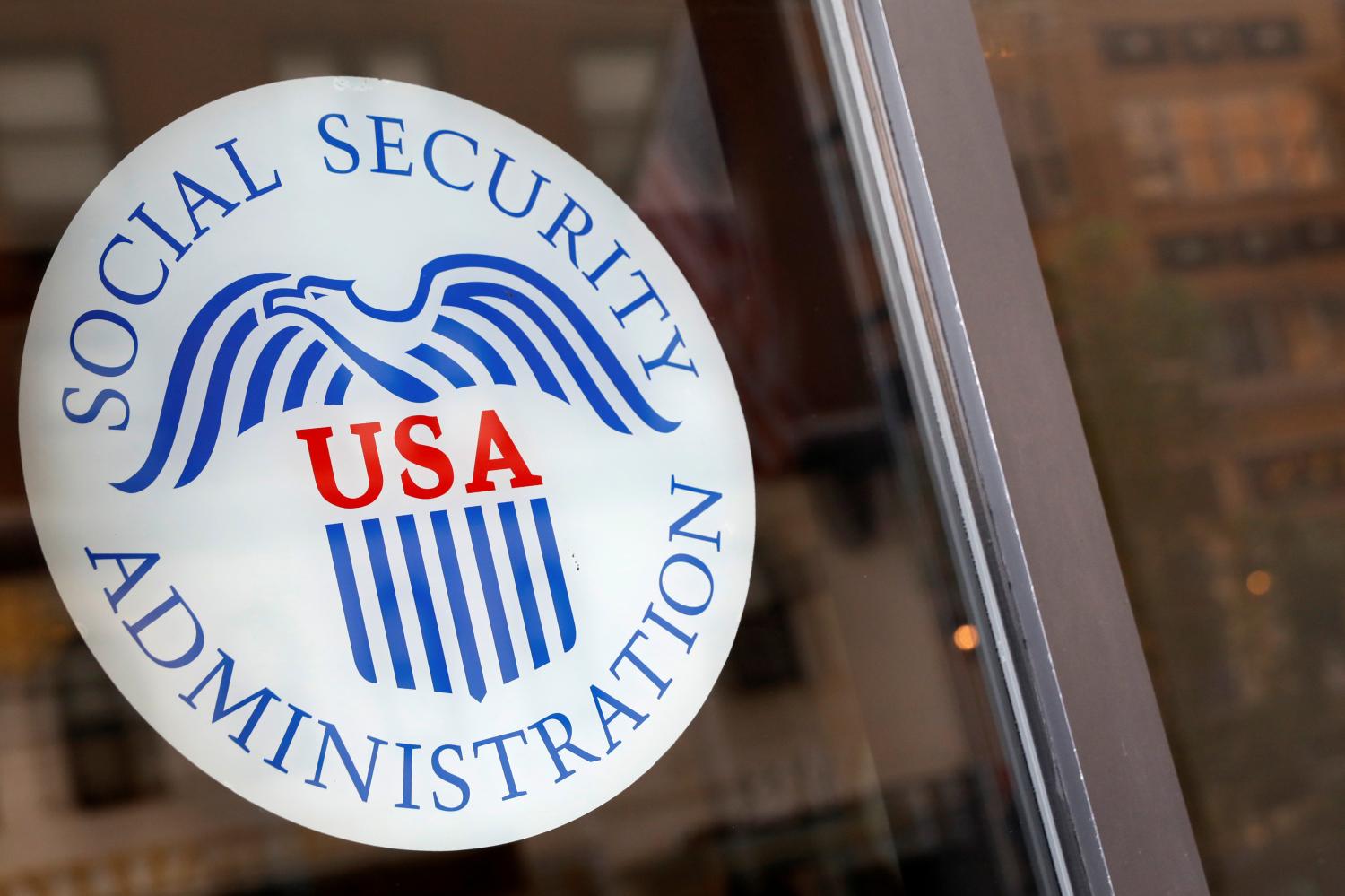 A sign is seen on the entrance to a Social Security office in New York City, U.S., July 16, 2018. REUTERS/Brendan McDermid - RC14BAB59BA0