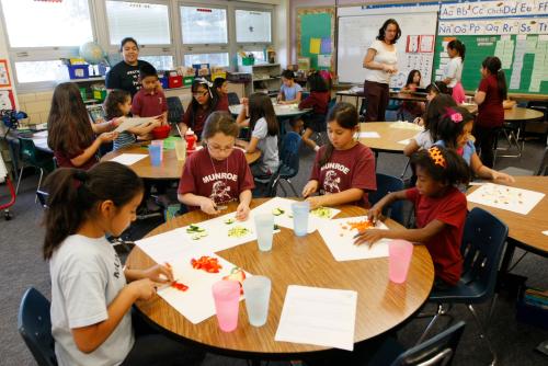 Students in the Munroe Elementary School after-school garden club (L-R) Anai Carrillo, Jessica Grimaldo, Andrea Torres and Sandaley Haileseolph at the table in the foreground chop vegetables to put in a stir fry dish they would cook in Denver, Colorado May 9, 2012. The students learn to grow and prepare healthy meals in the school's garden club, with some of the food going to the school's lunch program. Colorado has the second fastest growing childhood obesity rate in the nation says non-profit LiveWell Colorado. Groups like Livewell are working to reduce childhood obesity by supporting school gardens, especially in low income areas, to provide learning about healthy food while actually providing nourishment. Studies have shown that children are more likely to try eating fresh fruit and vegetables if they are involved in growing them.  Photo taken May 9, 2012.  REUTERS/Rick Wilking (UNITED STATES - Tags: HEALTH EDUCATION SOCIETY) - TM3E85F16B801