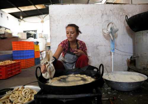 A woman makes traditional sweets called Lakhamari inside a sweet factory before selling it to the market for the Tihar festival, also called Diwali, in Kathmandu, Nepal November 5, 2018. REUTERS/Navesh Chitrakar - RC161A1F1490