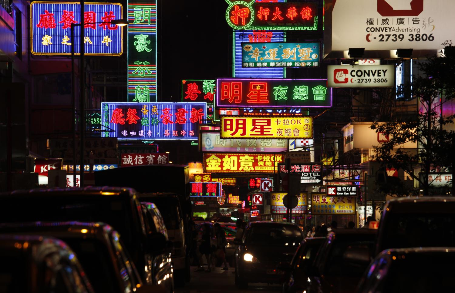 ATTENTION EDITORS - IMAGE 5 OF 22 OF PICTURE PACKAGE '7 BILLION, 7 STORIES - OVERCROWDED IN HONG KONG. SEARCH 'MONG KOK' FOR ALL IMAGES - Cars cross a street in Mong Kok district in Hong Kong, October 4, 2011. Mong Kok has the highest population density in the world, with 130,000 in one square kilometre. The world's population will reach seven billion on 31 October 2011, according to projections by the United Nations, which says this global milestone presents both an opportunity and a challenge for the planet. While more people are living longer and healthier lives, says the U.N., gaps between rich and poor are widening and more people than ever are vulnerable to food insecurity and water shortages.   Picture taken October 4, 2011.   REUTERS/Bobby Yip   (CHINA - Tags: SOCIETY) - LM2E7AE1A6R01