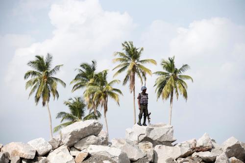 A policeman stands guard atop rocks overlooking the proposed Dangote oil refinery site during a facility tour near Akodo beach in the outskirt of Nigeria's commercial capital Lagos June 25, 2016. REUTERS/Akintunde Akinleye - S1BETLZHQAAA