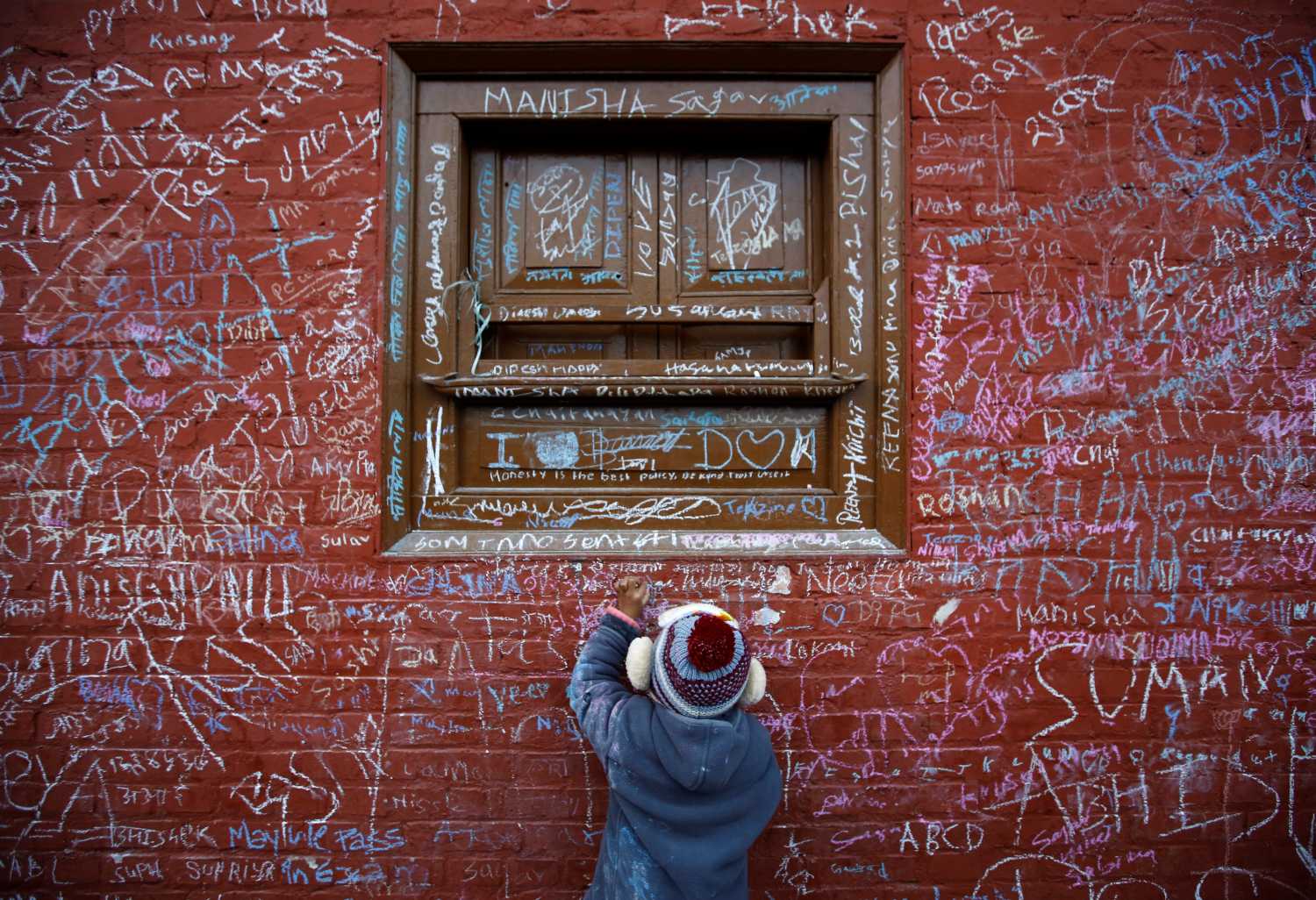 A child writes with chalk on a wall to celebrate Shreepanchami festival at Saraswati temple in Kathmandu, Nepal February 1, 2017. Children are given their first writing and reading lessons at the temple during this festival in the belief that the goddess of education Saraswati will help them excel in education. REUTERS/Navesh Chitrakar     TPX IMAGES OF THE DAY - RC197B507EC0