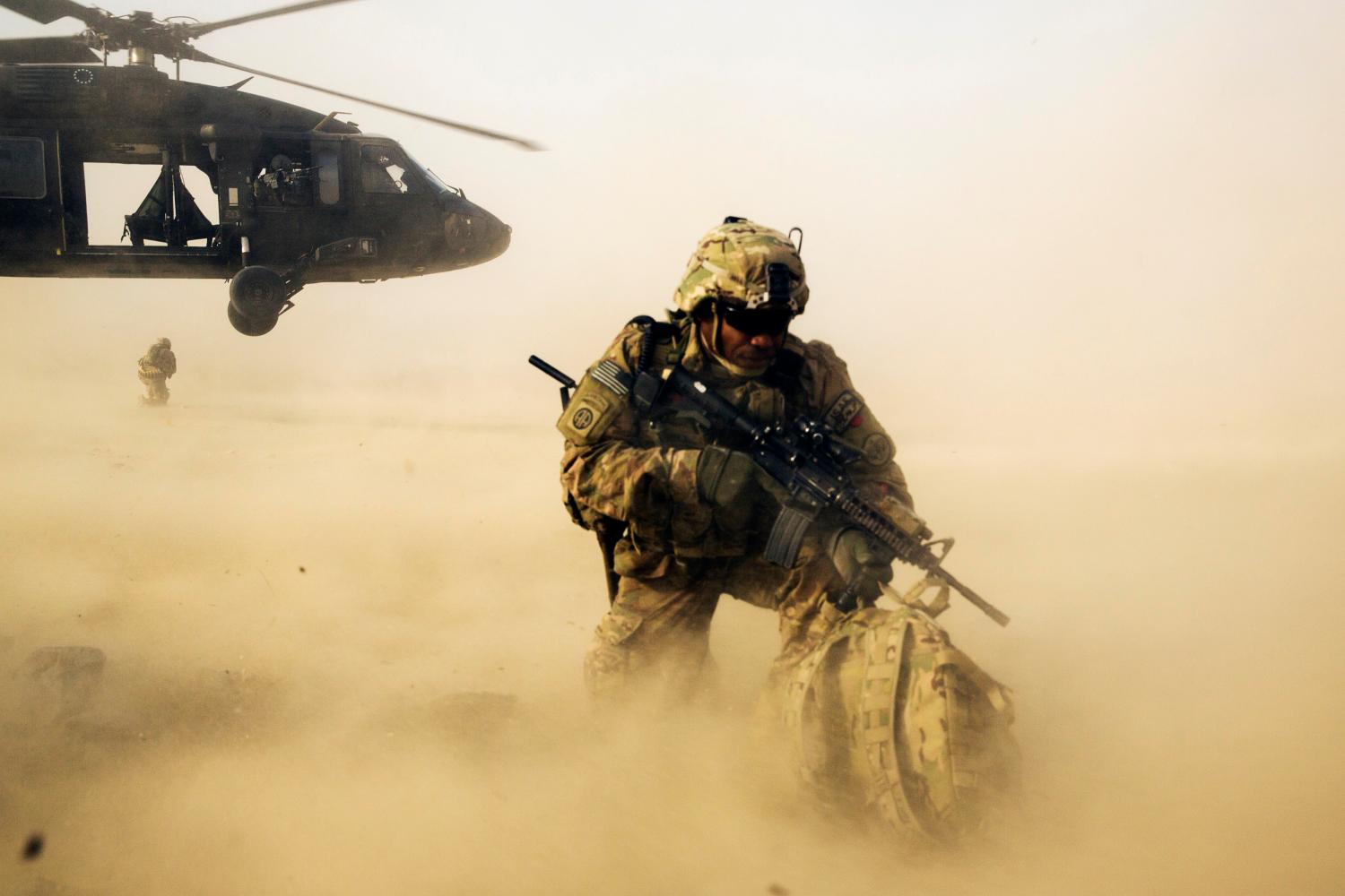 A U.S. soldier from the 3rd Cavalry Regiment shields himself from the rotor wash of a UH-60 Blackhawk helicopter after being dropped off for a mission with the Afghan police near Jalalabad in the Nangarhar province of Afghanistan December 20, 2014. REUTERS/Lucas Jackson (AFGHANISTAN - Tags: TRANSPORT CIVIL UNREST MILITARY POLITICS TPX IMAGES OF THE DAY) - GM1EACK1LDW01