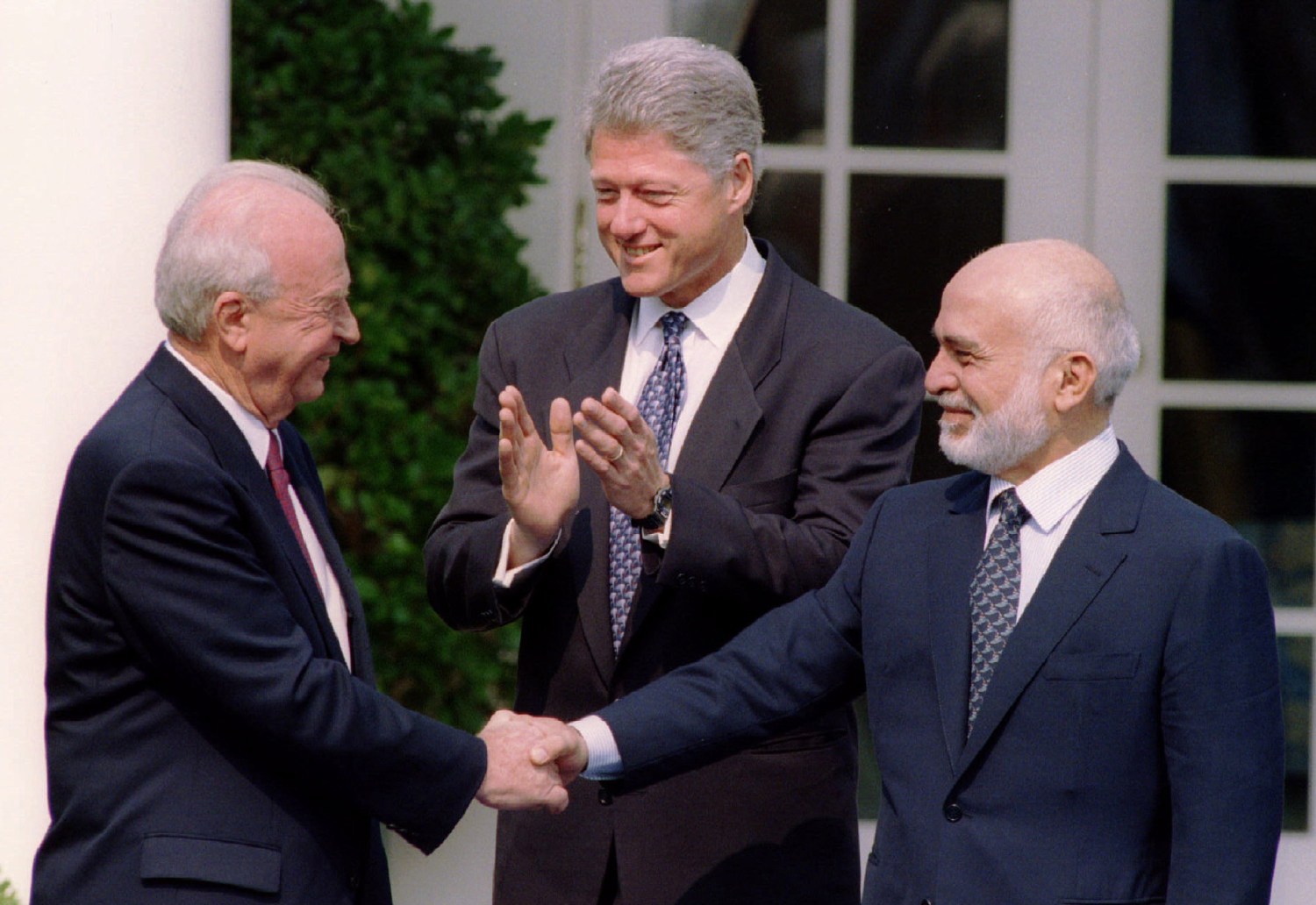 Israeli Prime Minister Yitzhak Rabin (L) and Jordan's King Hussein (R) grasp hands enthusiastically at the start of a Rose Garden ceremony welcoming them to the White House as President Clinton applauds July 25, 1994 in Washington. The leaders of Israel and Jordan shook hands ending nearly a half-century of antagonism and signalling their intent to make a formal peace. SCANNED FROM NEGATIVE REUTERS/Gary C. Cameron  AVD/CMC - RP1DRICQYTAG