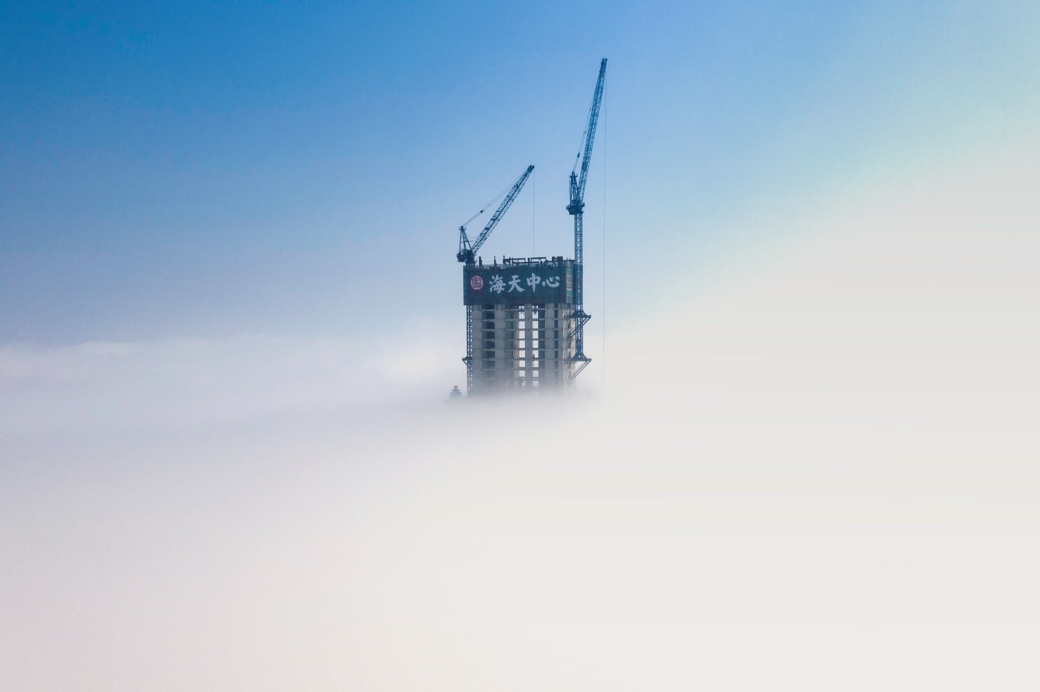 The skyscraper Haitian Center Tower under construction is seen amid cloud in Qingdao, Shandong province, China June 4, 2019. REUTERS/Stringer  ATTENTION EDITORS - THIS IMAGE WAS PROVIDED BY A THIRD PARTY. CHINA OUT. - RC15B920ABE0