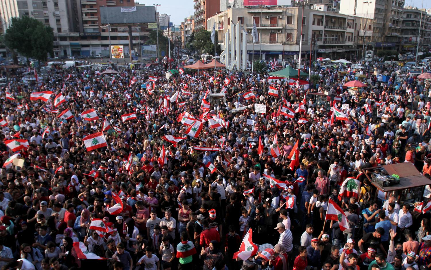 Demonstrators carry national flags during an anti-government protest in Tripoli, Lebanon October 22, 2019. REUTERS/Omar Ibrahim - RC1D594342A0