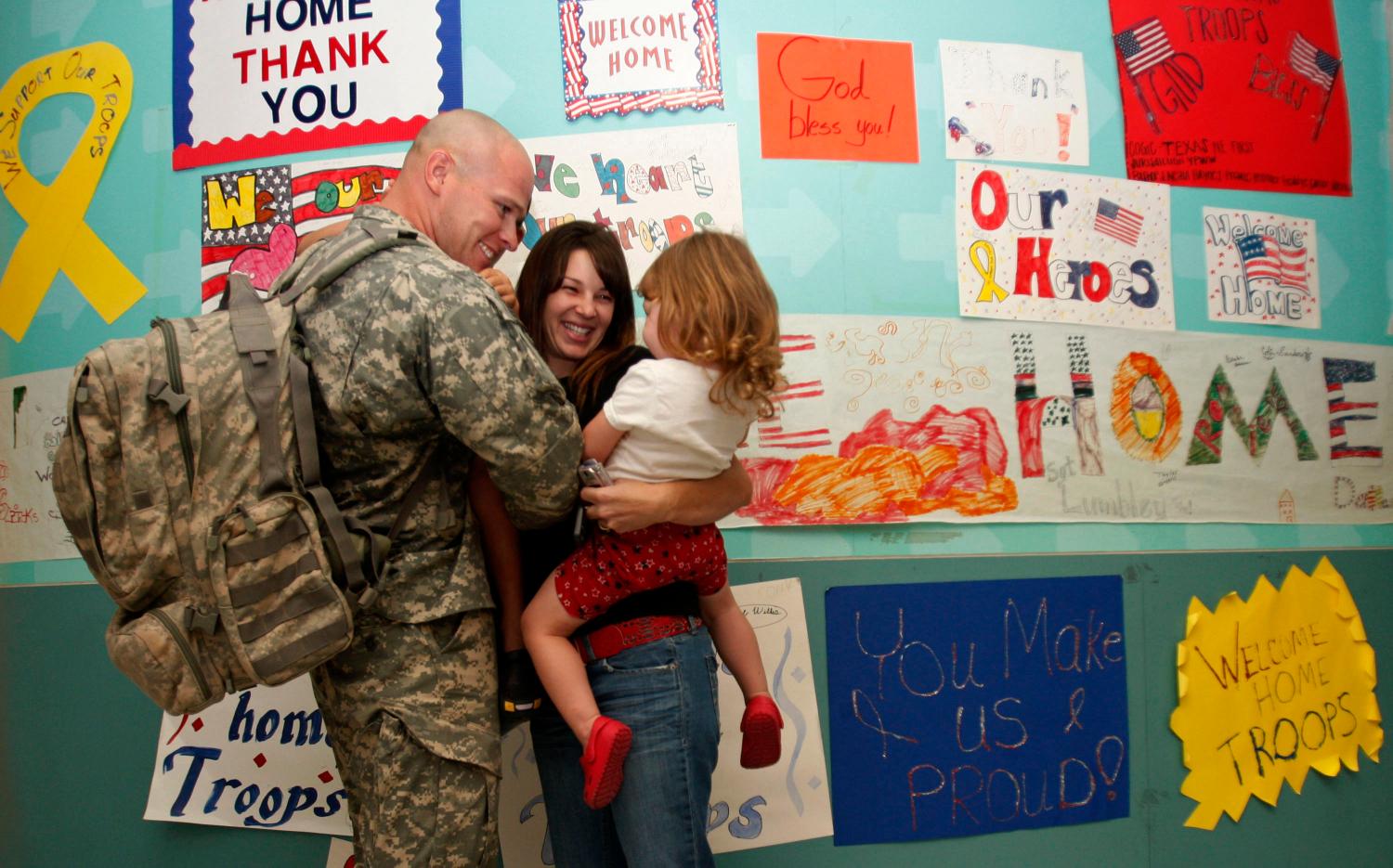 A military family reunites at DFW airport in Dallas, Texas, October 22, 2008. Among those struggling in the worst financial crisis since the Great Depression are members of the U.S. armed forces and their families. Picture taken October 22, 2008. To match feature FINANCIAL/MILITARY REUTERS/Jessica Rinaldi (UNITED STATES) - GM1E4AS1CUD01