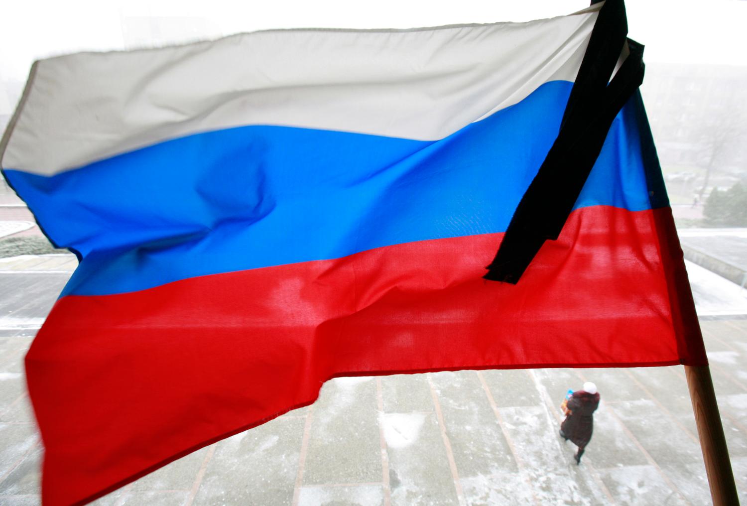 The Russian flutters at half staff as the country observes a day of mourning for victims of the Perm's fired nightclub in the southern city of Stavropol, December 7, 2009. Russia observed a national day of mourning on Monday for the 112 victims of a weekend nightclub blaze, as investigators stepped up their probe into fire safety breaches and burials continued in Perm.  REUTERS/Eduard Korniyenko  (RUSSIA DISASTER OBITUARY) - GM1E5C71H6Y01