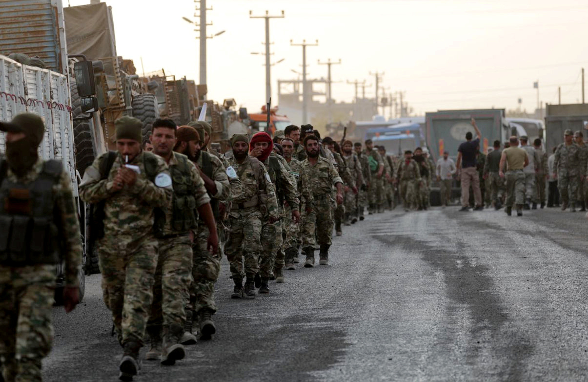 Turkey-backed Syrian rebel fighters walk together in the border town of Akcakale in Sanliurfa province, Turkey, October 11, 2019. REUTERS/Khalil Ashawi - RC151BCB1700