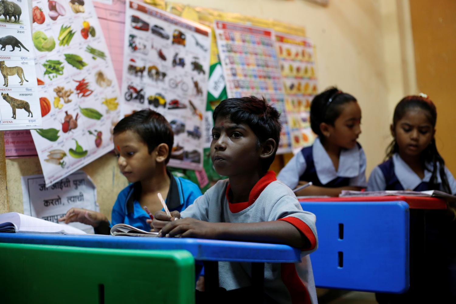 Siddharth Dhage, 10, sits at his desk in a classroom at a school in Aurangabad, India, July 18, 2019. Dhage is among a small group of children who take a 14 km (9 miles) return train journey from their village in India to fetch water. "I don't like to spend time bringing water, but I don't have a choice," Dhage said. REUTERS/Francis Mascarenhas  SEARCH "MASCARENHAS DROUGHT" FOR THIS STORY. SEARCH "WIDER IMAGE" FOR ALL STORIES. - RC138B42F900