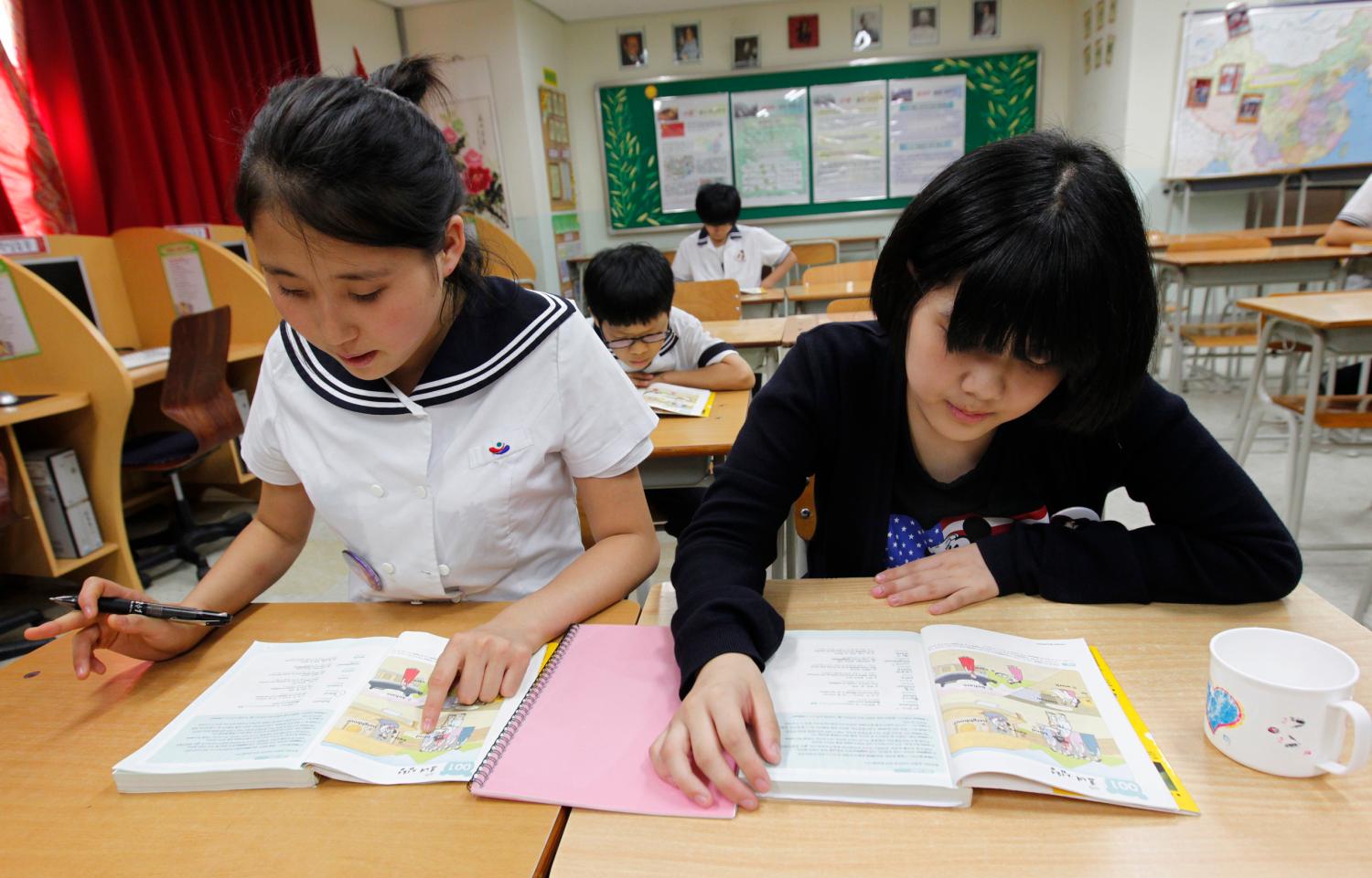 Lim Myeong-hee (L), 16, and her friend, middle school students who defected from North Korea, memorize English words as they look at English textbooks during supplementary lessons at the Hangyeore Middle and High School in Anseong, about 80 km (50 miles) south of Seoul, July 21, 2011. From the start of the 1950-53 Korean War till 1998, the total number of defectors in South Korea stood at less than 1,000. Today, the number is around 23,000. South Korean government last month started building a second reception centre for North Korean defectors at Hwacheon, about half an hour's drive from the border. Picture taken on July 21, 2011. To match feature KOREA-NORTH/DEFECTORS.  REUTERS/Jo Yong-Hak (SOUTH KOREA - Tags: POLITICS MILITARY EDUCATION) - GM1E78M1DEV01