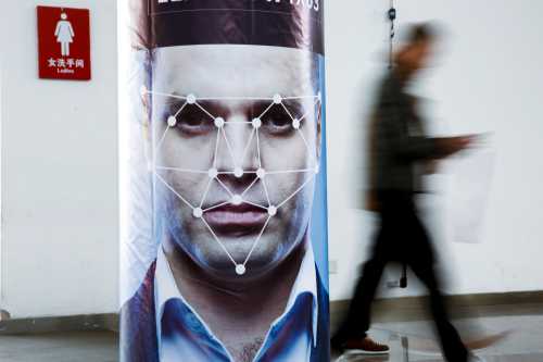 A man walks past a poster simulating facial recognition software at the Security China 2018 exhibition on public safety and security in Beijing, China October 24, 2018.   REUTERS/Thomas Peter - RC195B4D37A0