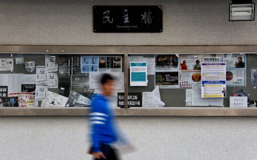 A man walks past "Democracy Wall" outside the library of the University of Hong Kong February 17, 2015. A campus election at the top Hong Kong university degenerated into an acrimonious campaign against mainland Chinese candidates, highlighting simmering tensions two months after pro-democracy protests led by local students paralysed parts of the city. Picture taken February 17, 2015. REUTERS/Bobby Yip  (CHINA - Tags: POLITICS EDUCATION) - GM1EB2I0EXC01