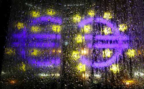 The euro sign in front of the former headquarters of the European Central Bank (ECB) is reflected in a rain covered window during heavy rain in Frankfurt, Germany, November 20, 2017.  REUTERS/Kai Pfaffenbach - RC1F8AC74E00