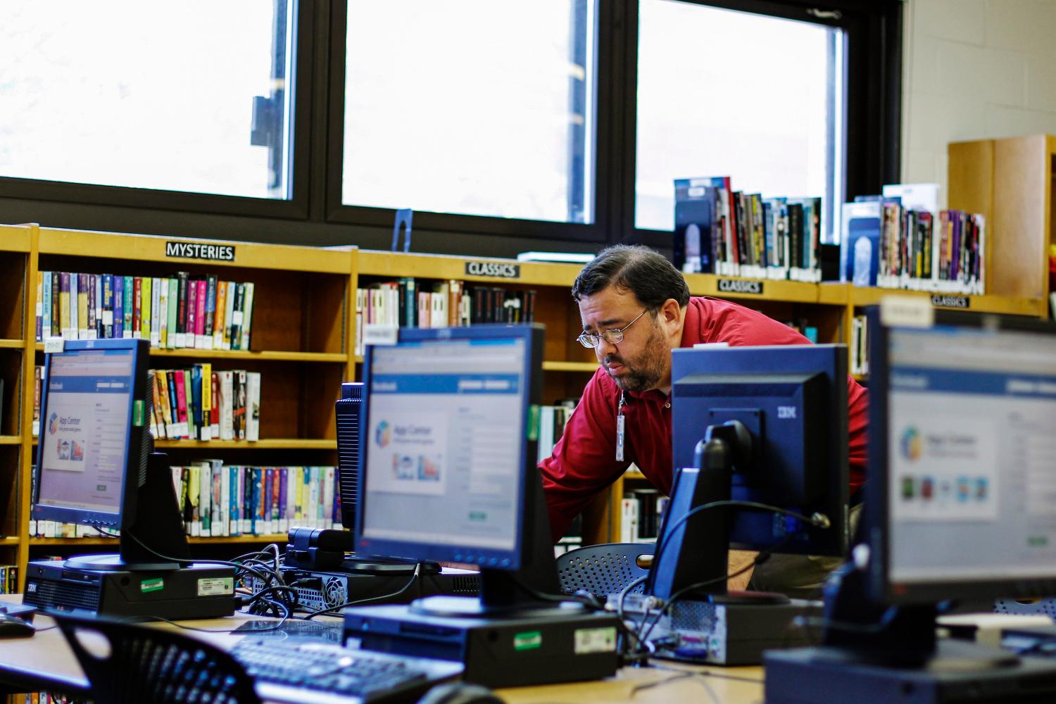 Librarian Josh Soule turns on computers in preparation to teach senior citizens how to set up and use a Facebook account during a class at a branch of the New York Public Library in New York August 13, 2012. Seniors, some in their 90s, could soon be making new friends on Facebook thanks to New York libraries offering classes to help the elderly learn, or brush up their social network skills. REUTERS/Lucas Jackson (UNITED STATES - Tags: SOCIETY SCIENCE TECHNOLOGY EDUCATION) - GM2E88E0HHA01