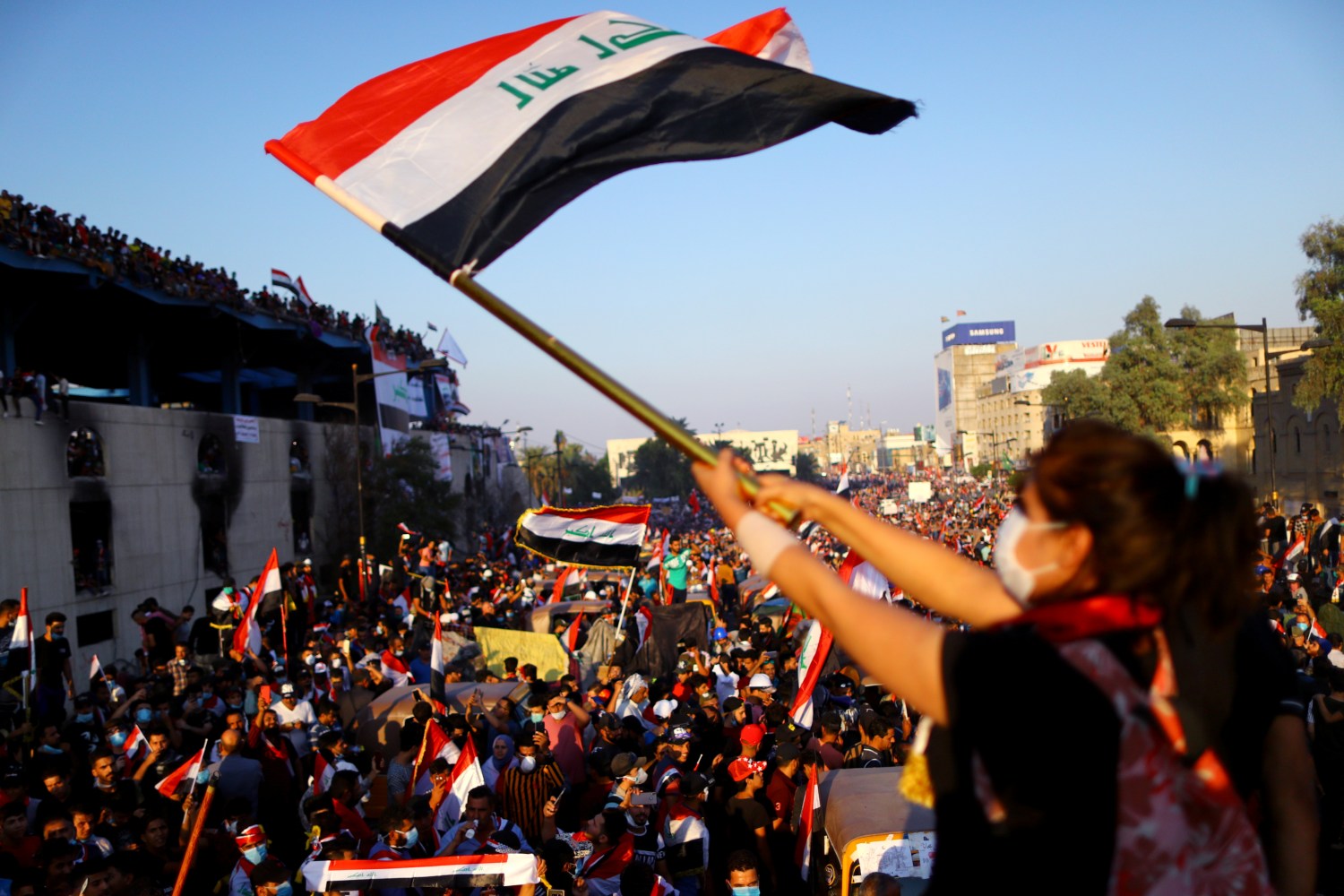 An Iraqi female demonstrator waves an Iraqi flag during an ongoing anti-government protest, in Baghdad, Iraq November 1, 2019. REUTERS/Ahmed Jadallah - RC164BCA0C20