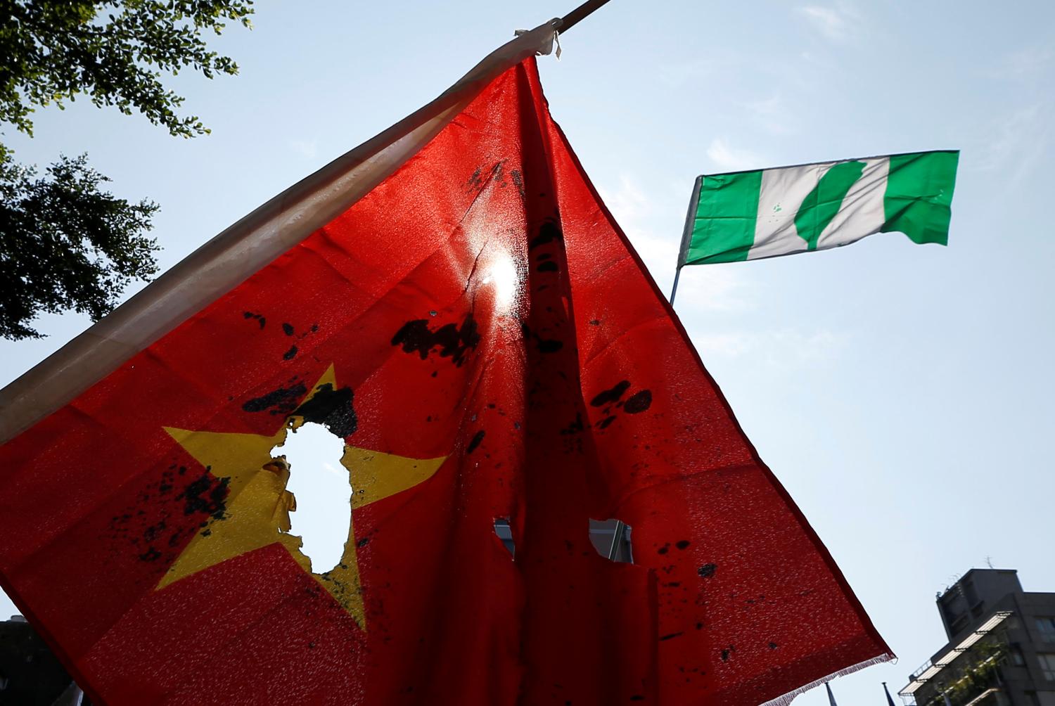 Anti-China protester carry burnt China national flag and so-called Taiwanese independence flag (back) during a protest before the  opening ceremony of Taipei-Shanghai forum, in Taipei, Taiwan August 23, 2016. REUTERS/Tyrone Siu - S1BETXAHZJAA