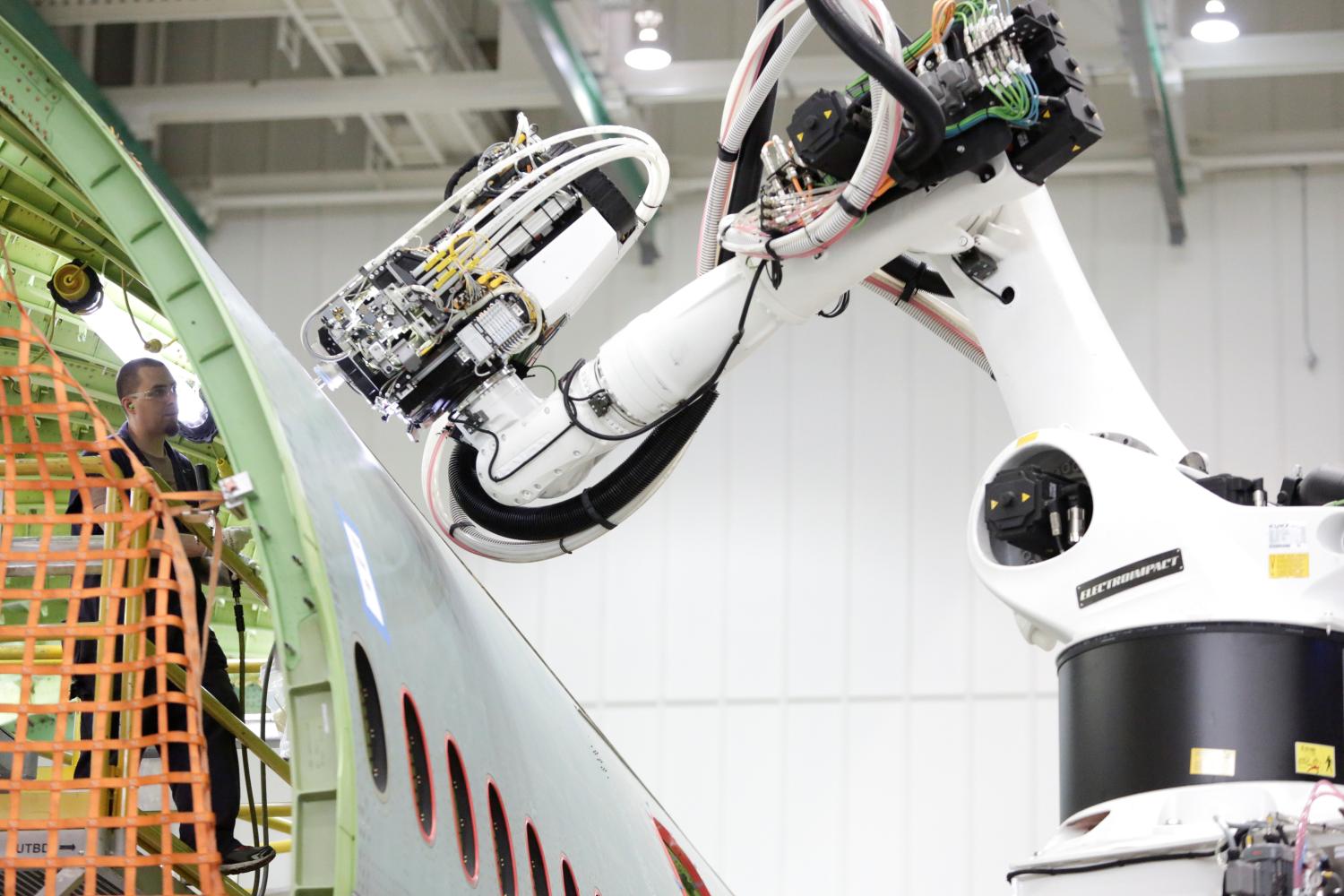 A worker (L) stands inside a 777 fuselage as a machine works on the outside at the Fuselage Automated Upright Build (FAUB) and mid bodies area at Boeing's production facility in Everett, Washington, U.S. June 1, 2017. Picture taken June 1, 2017. REUTERS/Jason Redmond - RC1F14027B00