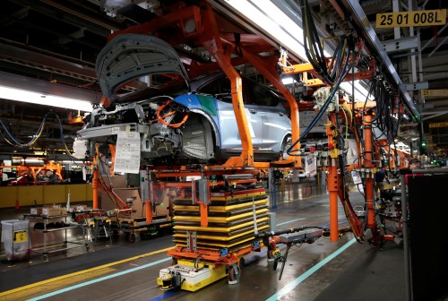 An automated guided vehicle carrying a battery pack moves under a partially assembled 2018 Chevrolet Bolt EV vehicle on the assembly line at General Motors Orion Assembly in Lake Orion, Michigan, U.S., March 19, 2018.  Photo taken March 19, 2018.   REUTERS/Rebecca Cook - RC16181E9F00