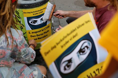 Members of the activist group Party Rebels, paste up posters alerting people to an organised protest against the face veil ban in Copenhagen, Denmark, July 23, 2018. REUTERS/Andrew Kelly    SEARCH "DENMARK VEIL" FOR THIS STORY. SEARCH "WIDER IMAGE" FOR ALL STORIES. THE IMAGES SHOULD ONLY BE USED TOGETHER WITH THE STORY - NO STAND-ALONE USES - RC18C98ABA00