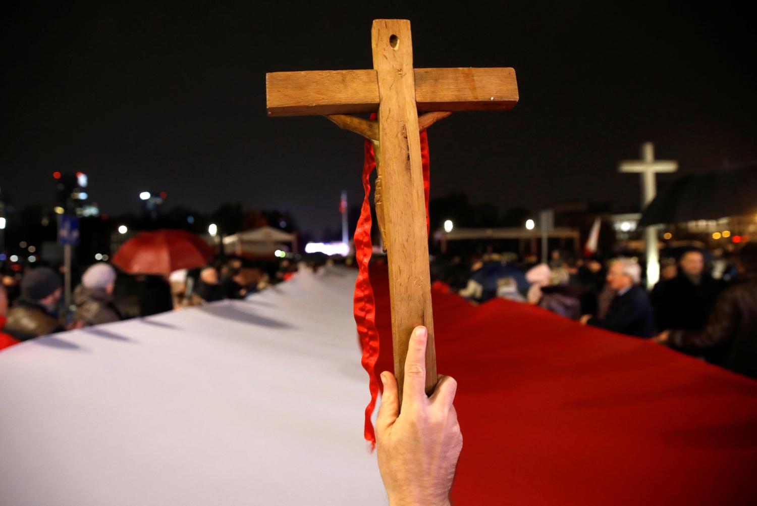 A person holds up a wooden cross during a march organized by Poland's ruling Law and Justice (PiS) party to commemorate victims of a plane crash that killed Poland's then-president and 95 other people, and to celebrate 101st anniversary of national independence, a day before the anniversary that will be marked by a mass march organized by far-right groups, in Warsaw, Poland November 10, 2019. REUTERS/Kacper Pempel - RC2K8D92BN55