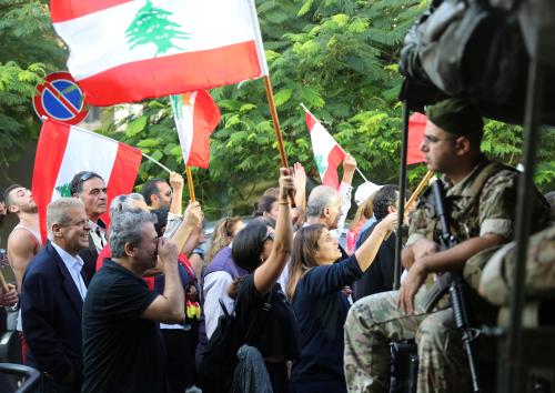 Demonstrators wave Lebanese flags as the pass by Lebanese soldiers during a protest in Beirut, Lebanon, October 31, 2019. REUTERS/Goran Tomasevic - RC116FDD2CA0