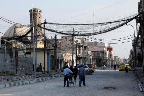 People walk on the street, where Islamic State leader Abu Bakr al-Baghdadi declared his caliphate back in 2014, in the old city of Mosul, Iraq, October 27, 2019. REUTERS/Abdullah Rashid - RC1468923010